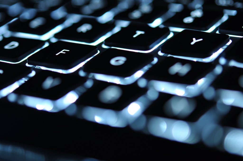 Backlit keyboard of laptop with letter F in focus.